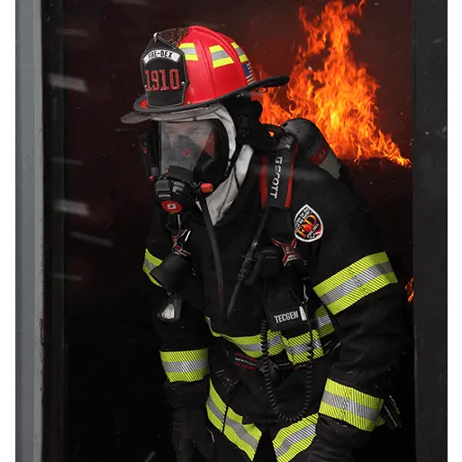 Firefighter wearing the Fire-Dex® H41 Interceptor with STEDAIR® Prevent jacket while exiting a flaming building, demonstrating protective coverage, reflective safety features, and mobility.