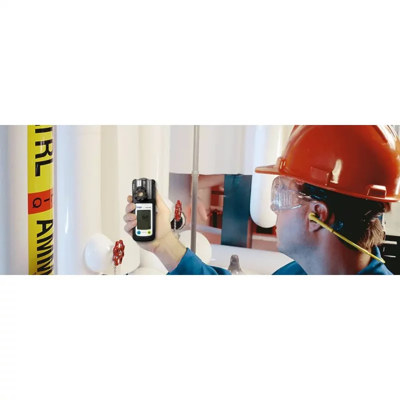 Worker using Dräger X-am® 5100 portable gas detector to test and monitor gas levels on-site for safety compliance.