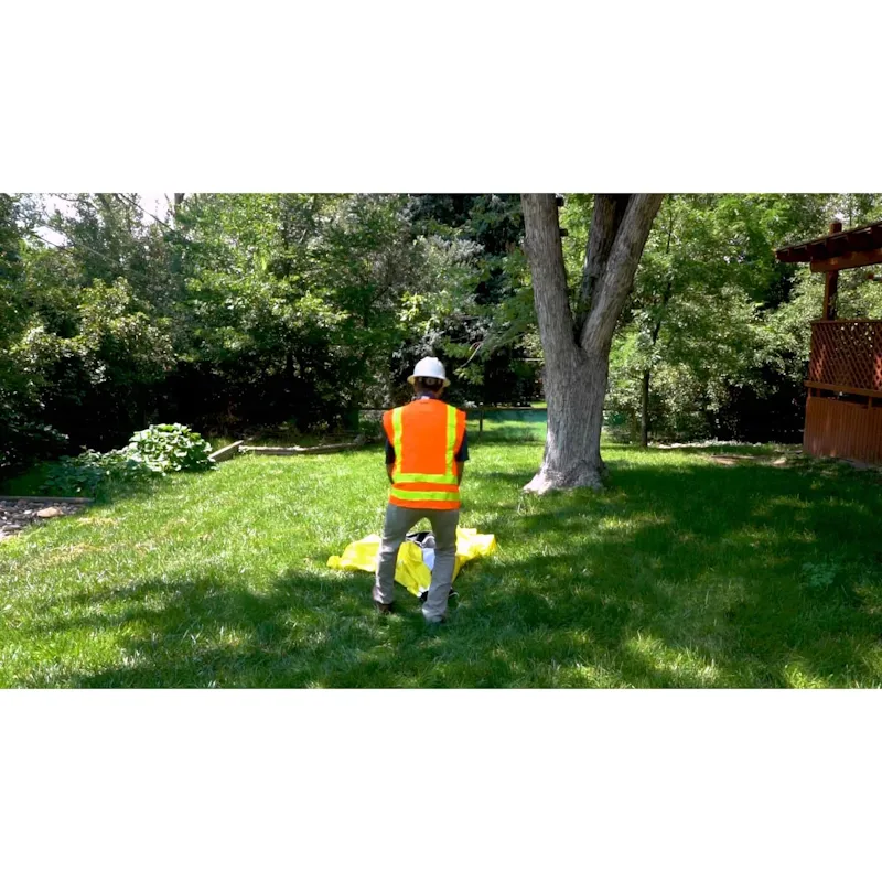 Person outside beginning to set up a Pelsue® Interlocking Series Work Tent, demonstrating ease of assembly and portability.