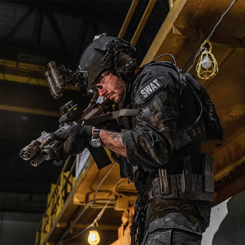 Military soldier armed indoors wearing the Team Wendy® EXFIL® Ballistic Helmet, showcasing its professional-grade protection and integration with communication equipment.