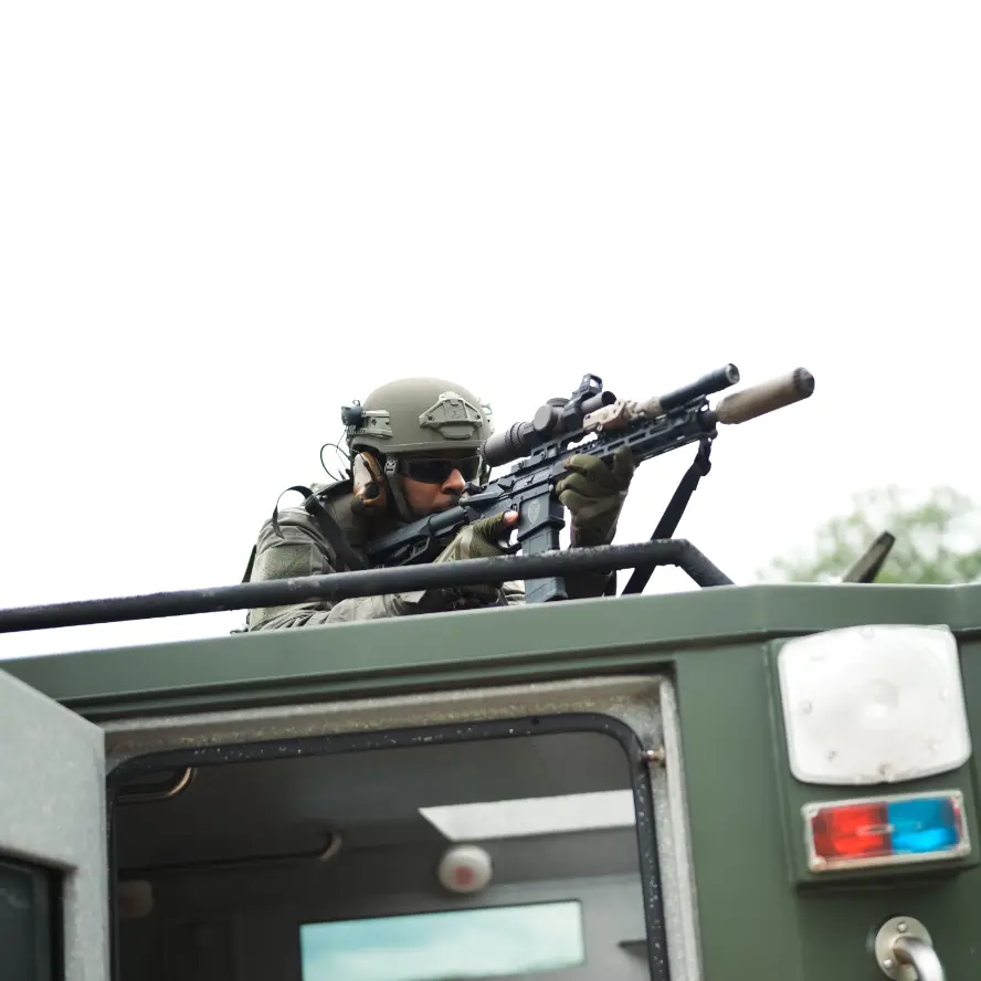 Soldier wearing the Team Wendy® EPIC™ Protector Ballistic Helmet armed on top of a truck outside, demonstrating its field-ready performance and compatibility with tactical gear.