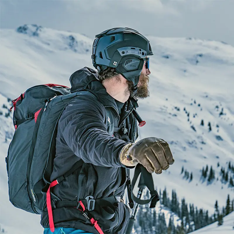 Person wearing Team Wendy® M-216™ Backcountry Ski Helmet while hiking in winter weather, demonstrating durable, lightweight, and protective outdoor headgear.