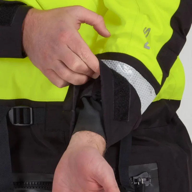 Closeup of a man wearing the NRS Extreme SAR Dry Suit in safety yellow, pulling the cuffs back to reveal inner wrist gaskets.