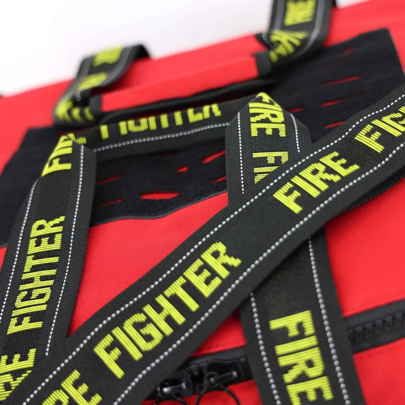 Close-up of the red Lightning X LXFB20 turnout gear bag's crisscrossed Fire Fighter webbing handles with reflective stitching.