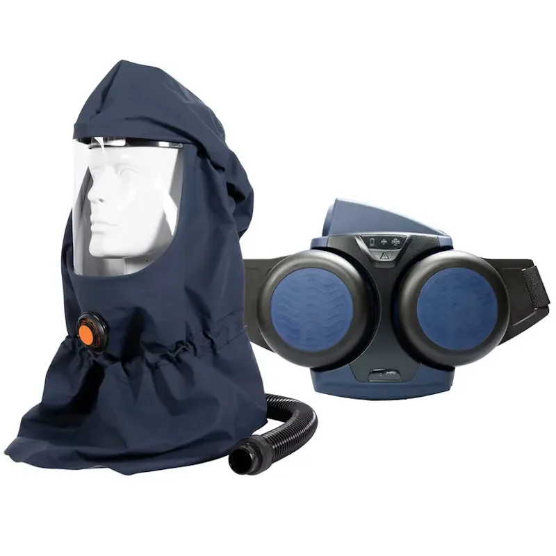 Sundström® SR 500/SR 530 powered air purifying respirator system in navy blue, featuring a soft fabric hood with a clear face shield, orange air flow connector, and breathing hose on a mannequin head beside the belt-worn blower unit with dual round filters and adjustable waist strap.