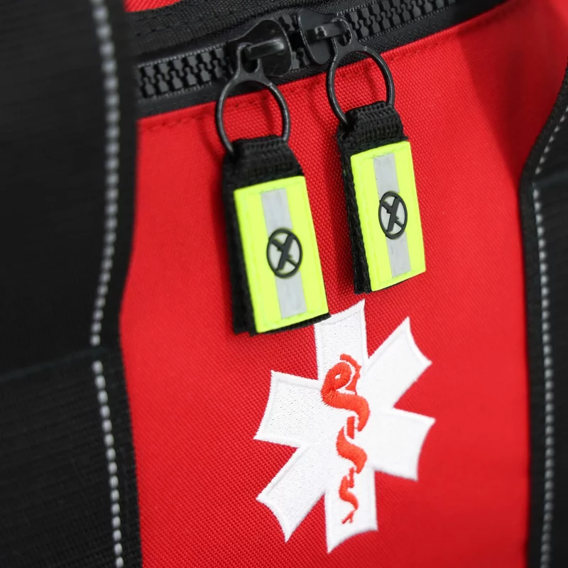 Closeup of medical emblem on Lightning X LXMB30 red variant large EMT first responder bag with zippers fully visible, showcasing clear identification and durable hardware.