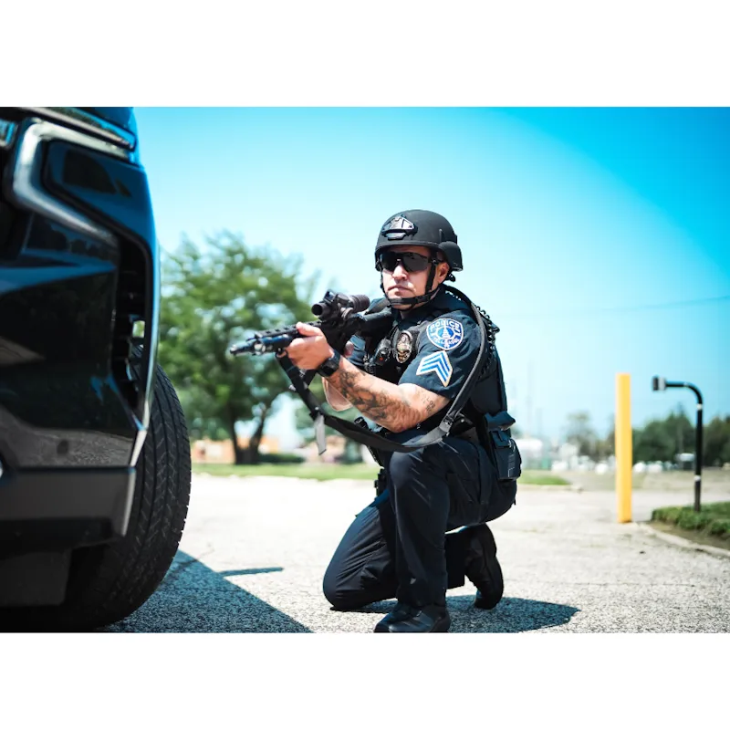 Policeman wearing the Team Wendy® EPIC™ Responder Ballistic Helmet outside while armed, demonstrating its professional fit, protection, and integration with tactical gear.
