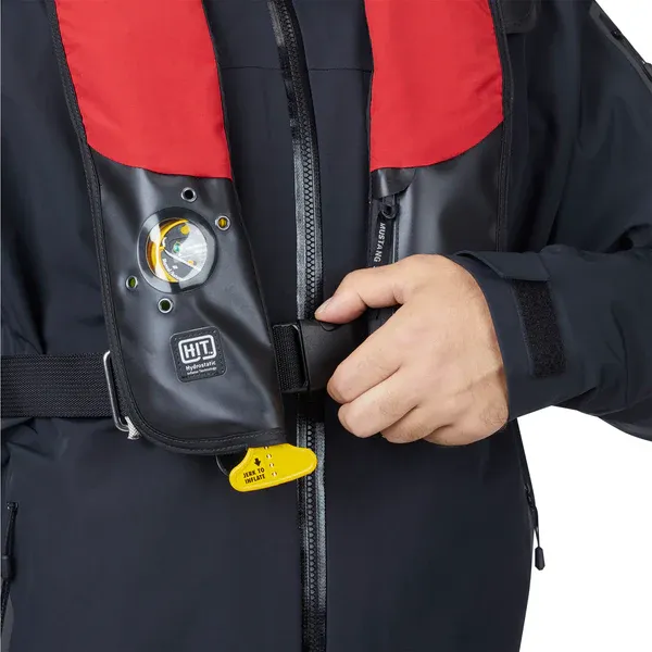 Close-up front view of a person wearing the Mustang Survival® HIT Hydrostatic Inflatable PFD in red/black variant, hydrostatic automatic inflatable life jacket for boating and marine safety.