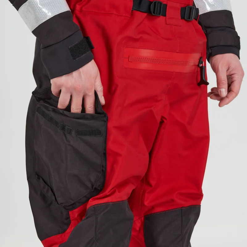 Closeup of a man wearing the NRS Extreme SAR Dry Suit in red with hands positioned near the waterproof pocket openings.