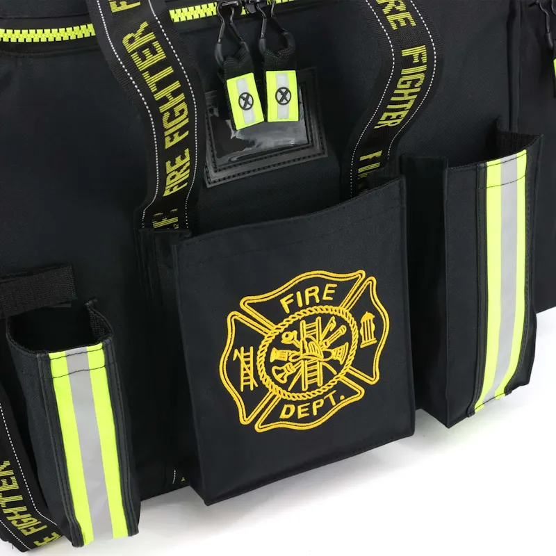 Close-up of the Lightning X LXFB20 black turnout gear bag's front pockets with embroidered Fire Dept. Maltese cross, reflective trim, and ID window.