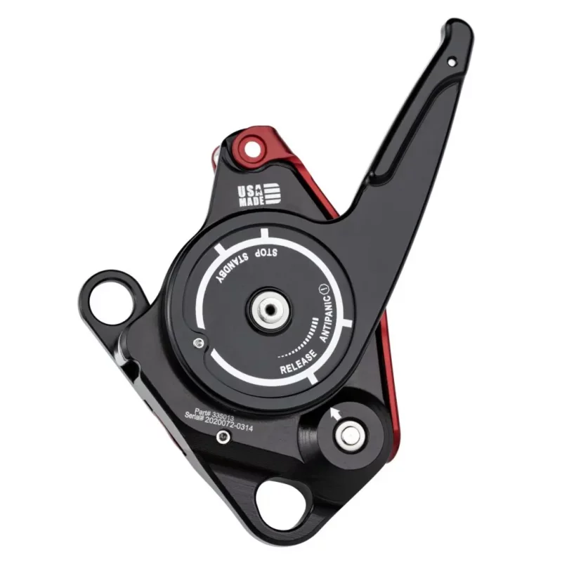 Back view of the red Harken™ CMC CLUTCH™ upside down with the switch pointed downward, displaying the rear housing and attachment point designed for secure, efficient rope access and rescue functionality.