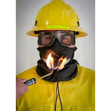 Front view of a person wearing the Hot Shield® UB-V2 Wildland Firefighter Ultimate Bandanna, demonstrating its flame-resistant properties as a flame is applied to the fabric without ignition or damage.