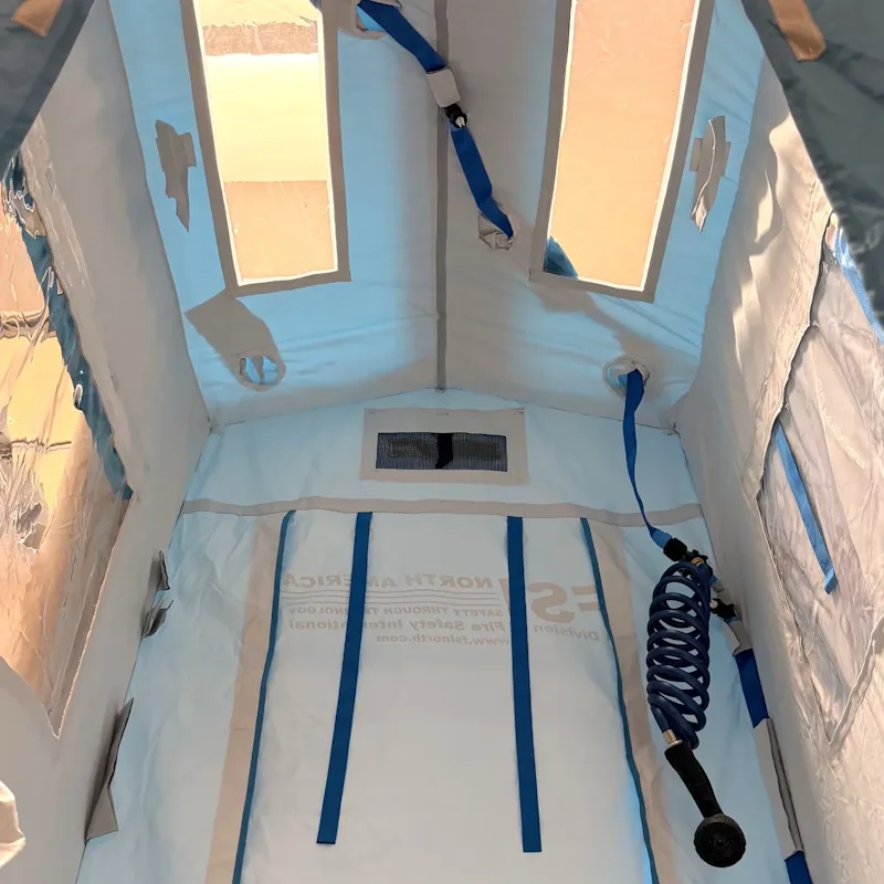 FSI® DAT1010S First Responder Decon Shower, interior view with coiled spray hose, skylights, and ceiling vent.