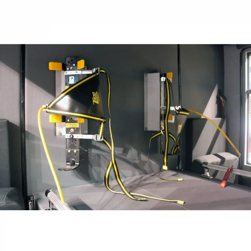 Two empty Ziamatic™ EZ-OUT SCBA Brackets mounted on a firetruck wall, ready to securely hold self-contained breathing apparatus (SCBA) cylinders with carrying straps for emergency use.