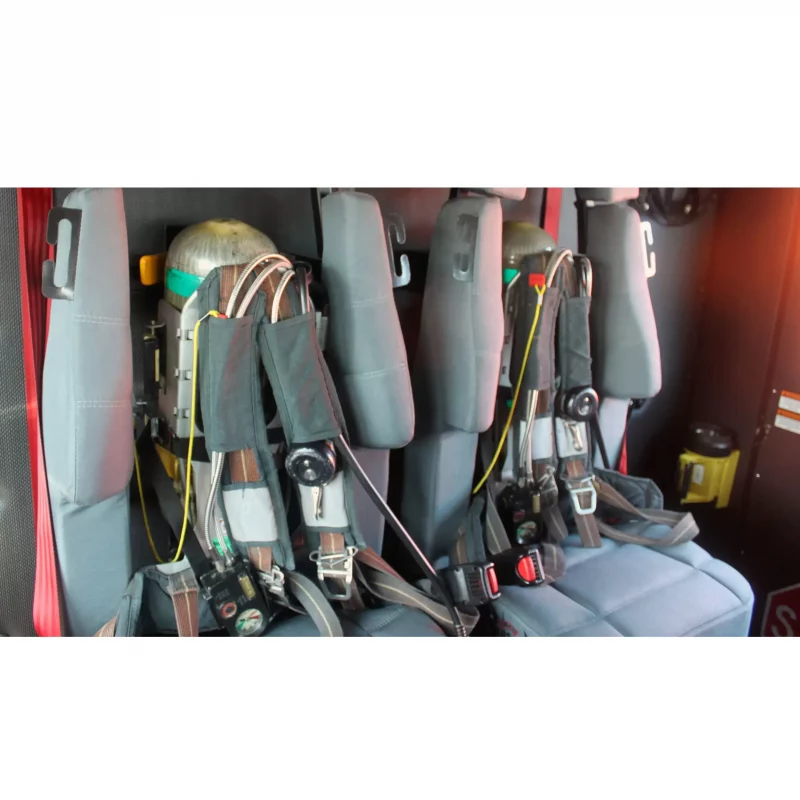 Two Ziamatic™ Load & Lock SCBA Brackets mounted on firetruck seats, each securely holding a self-contained breathing apparatus (SCBA) for immediate access during emergency response.