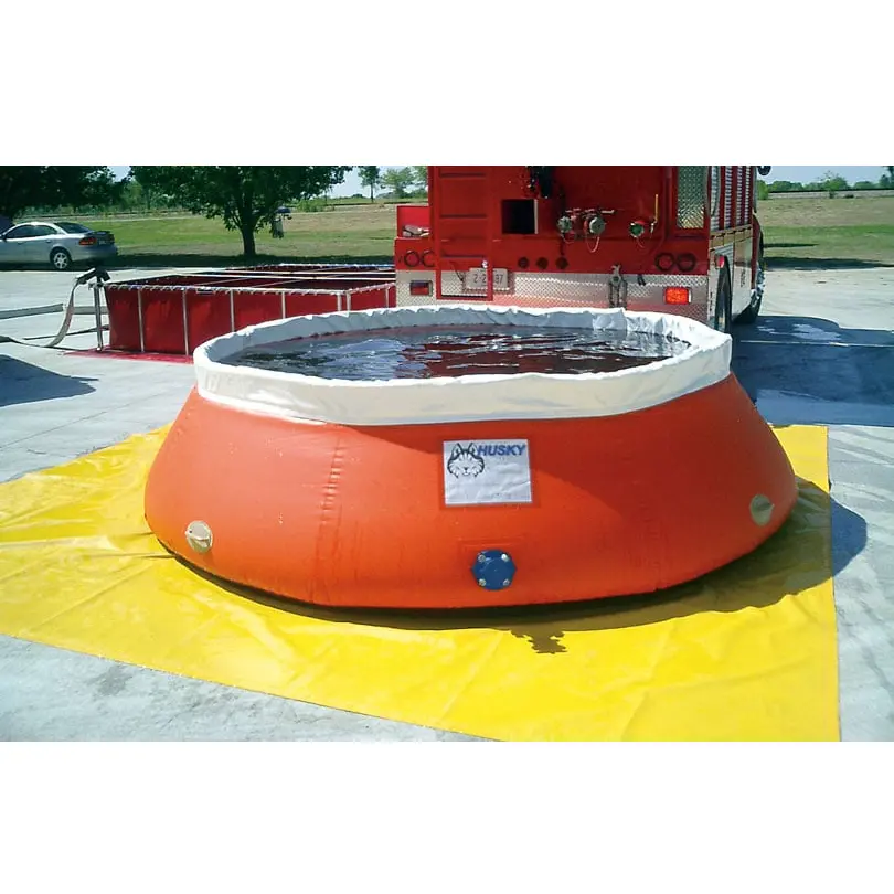 Yellow Husky® ground tarp under an orange self-supporting water tank filled with water, beside a fire truck and a frame-style folding tank.
