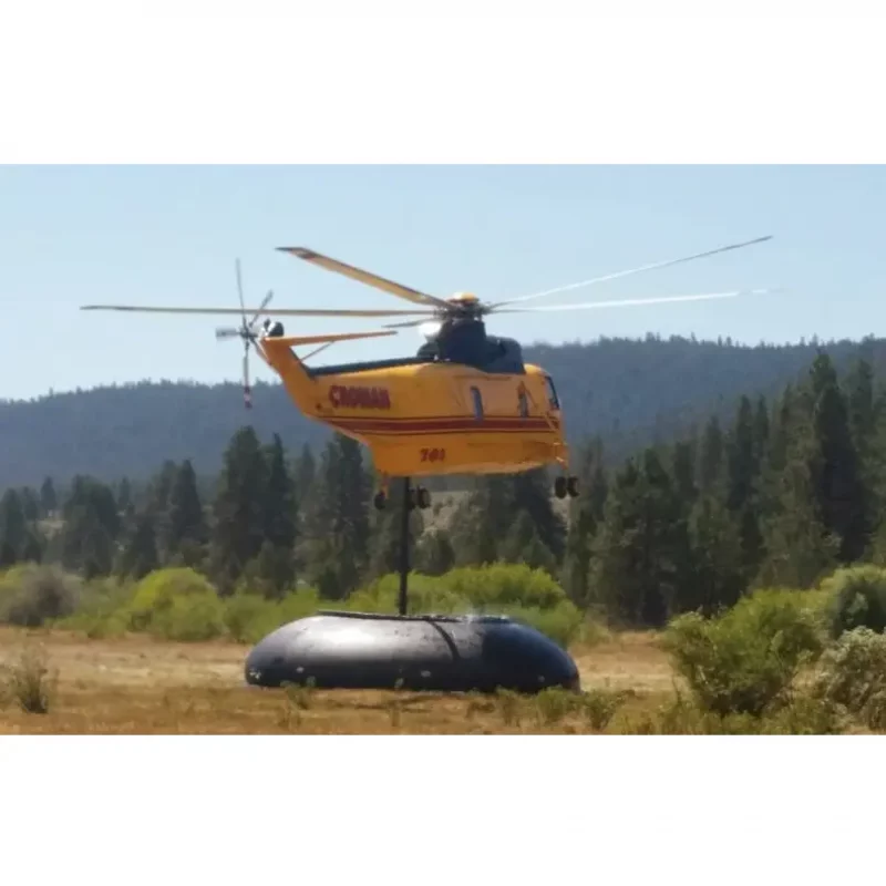 Distant view of a Husky® Self-Supporting Frameless Portable Water Tank supplying water for helicopter refueling during firefighting operations, demonstrating its reliable and portable water storage capability.