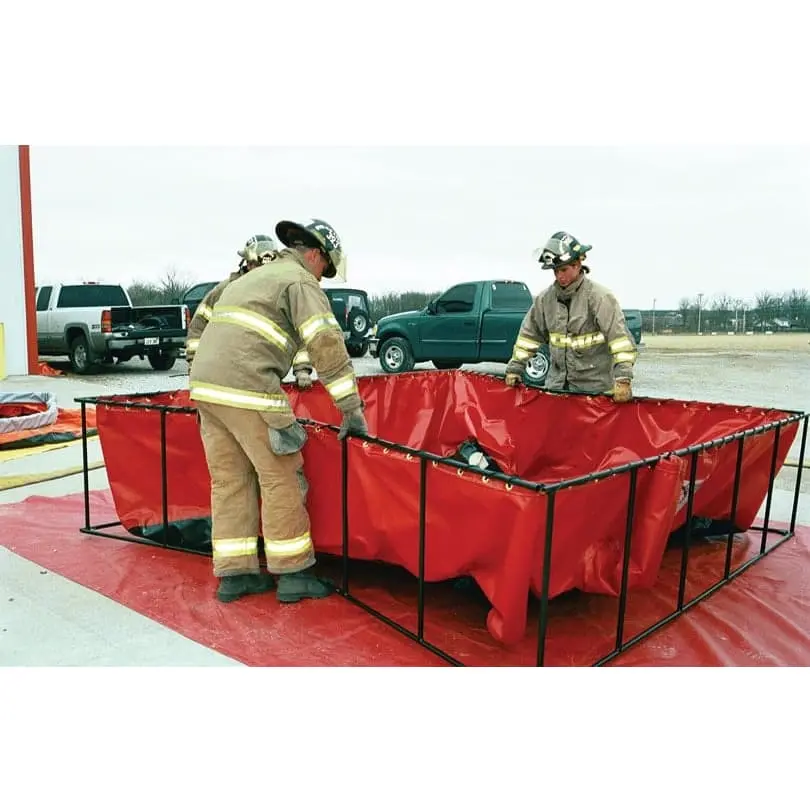 Firefighters setting up a red Husky® frame-style folding tank on a red Husky® ground tarp at a fire station.