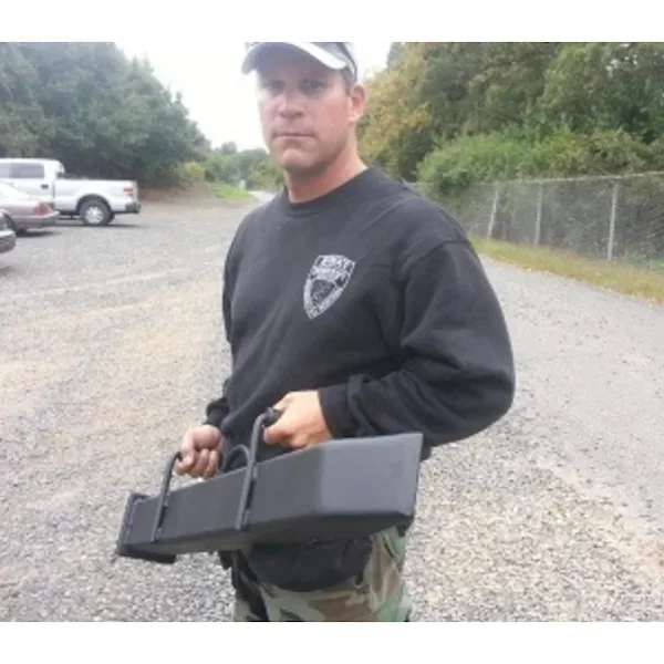 Person holding a JTC Wedge Ram by its dual handles on a gravel lot.