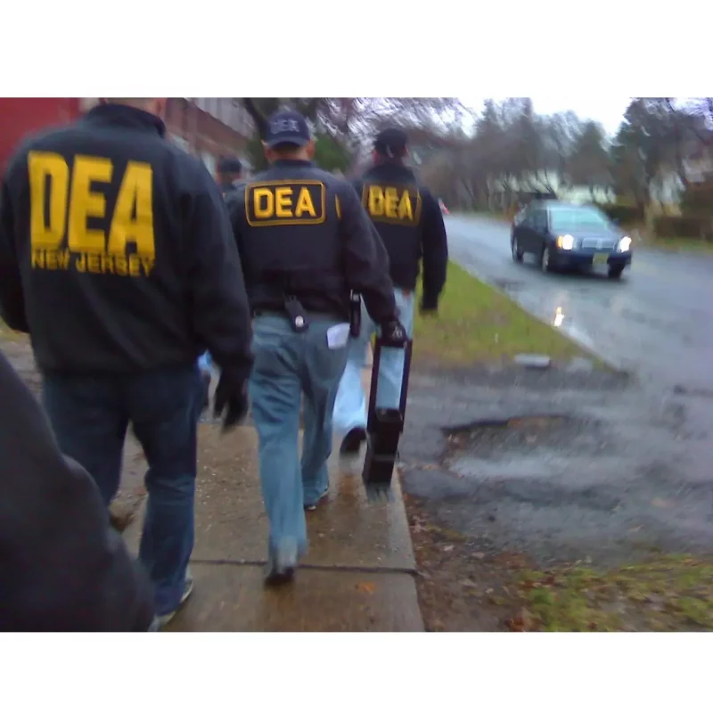 DEA agent holding the JTC Jersey Boot heavy-duty ram tool, featuring its solid steel construction and angled foot designed for powerful breaching and forcible entry.