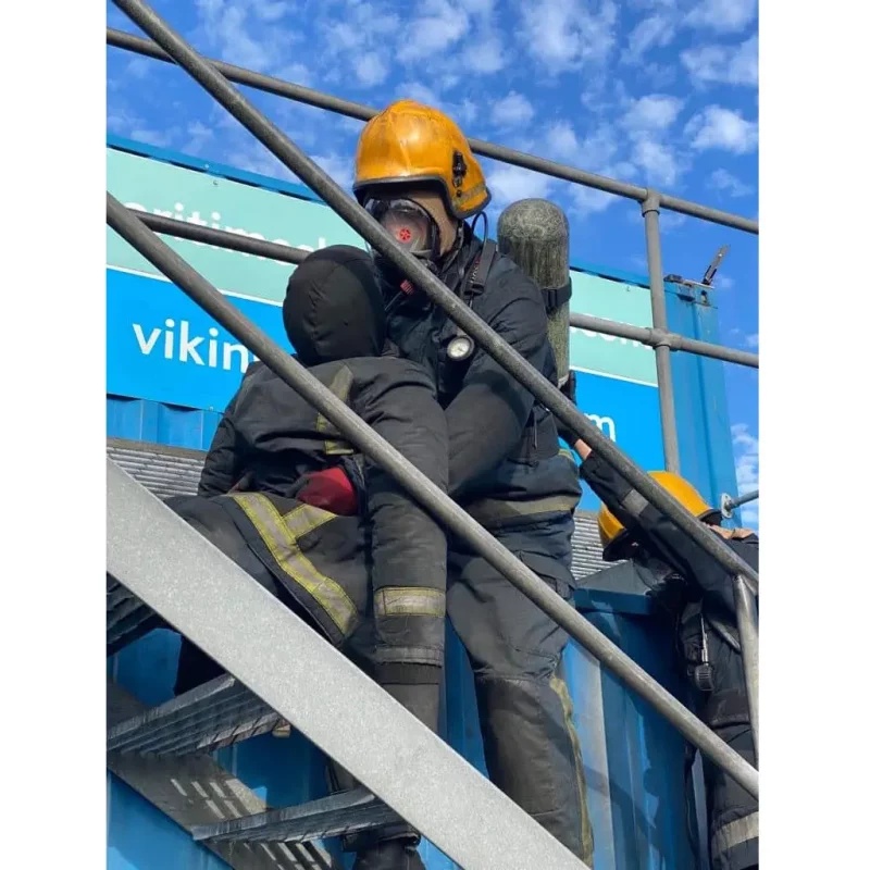 A Ruth Lee™ Fire House Training Manikin being held by a rescue trainer during a simulated emergency response training exercise.