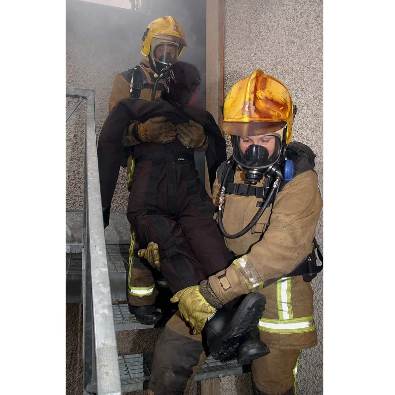 A Ruth Lee™ Fire House Training Manikin being carried down stairs by two rescue trainers during a simulated emergency evacuation drill.