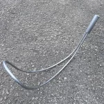 Northern Diver stainless steel Body Hook Reach Pole Attachment for water rescue, laid out on pavement showing its curved shepherd's-hook design and cylindrical grip end.