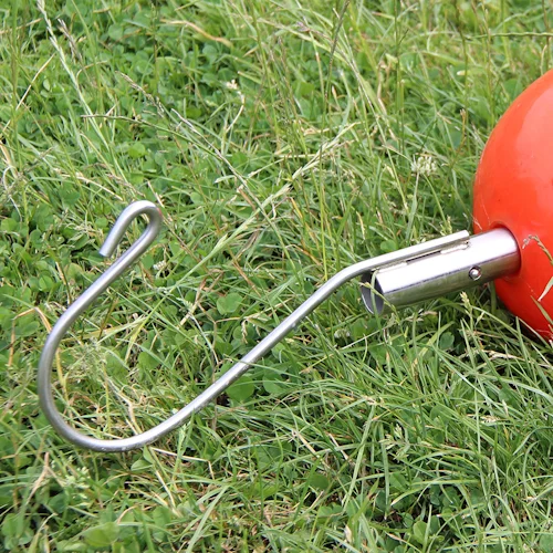 Northern Diver stainless steel Shepherd's Crook Reach Pole Attachment with curved hook end, fitted to orange buoy attachment and resting on grass.